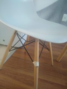 A partial image of a chair, with one leg wrapped in masking tape.