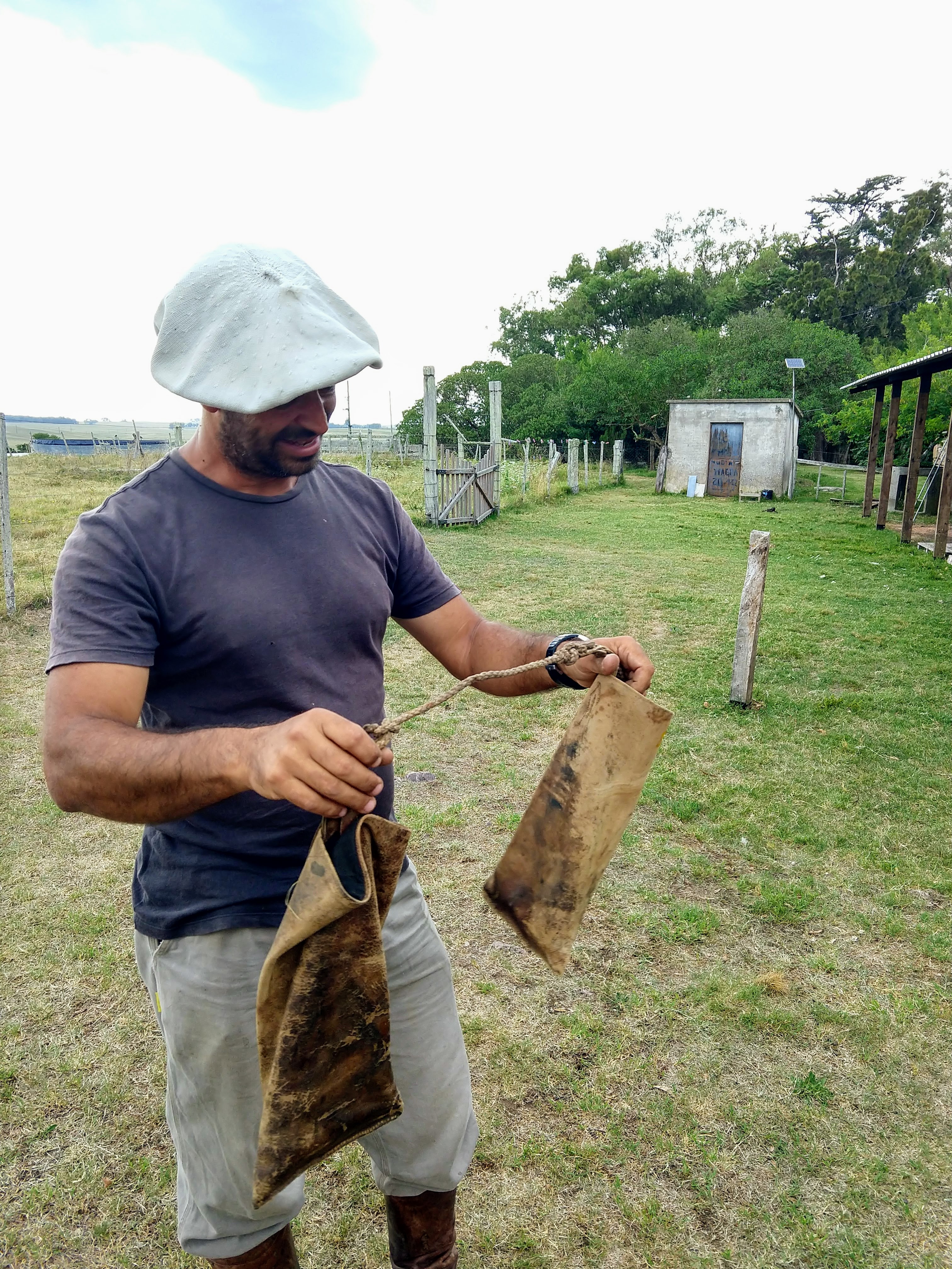 A man holds a small saddle bag set made from the calf section of old leather gaucho boots.